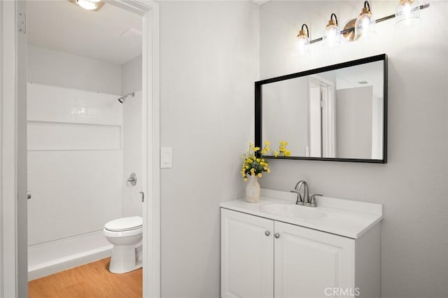 bathroom with vanity, toilet, wood-type flooring, and walk in shower