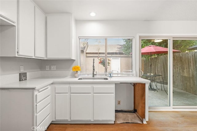 kitchen featuring white cabinets, plenty of natural light, sink, and light hardwood / wood-style flooring