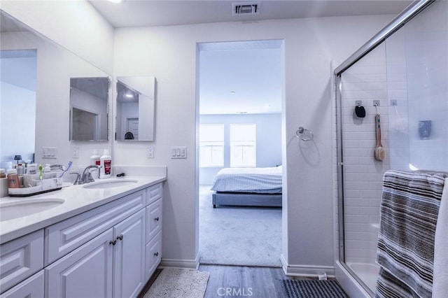 bathroom featuring wood-type flooring, an enclosed shower, and vanity