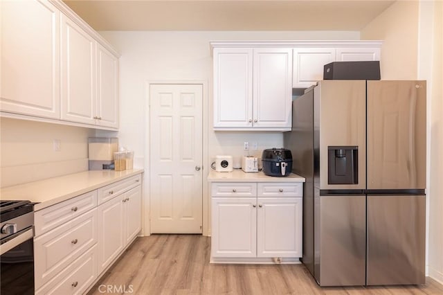 kitchen featuring light hardwood / wood-style floors, white cabinets, and appliances with stainless steel finishes