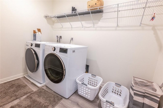 laundry room with wood-type flooring and washer and clothes dryer