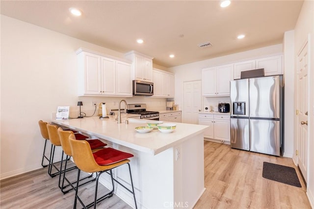 kitchen featuring kitchen peninsula, white cabinets, and appliances with stainless steel finishes