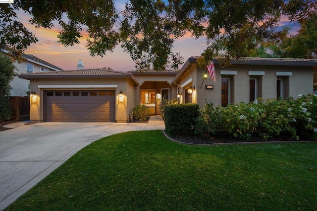 view of front facade with a garage and a lawn