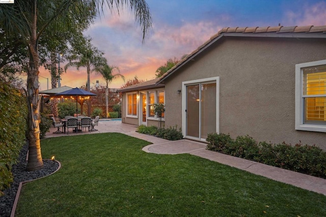 yard at dusk featuring a gazebo and a patio area