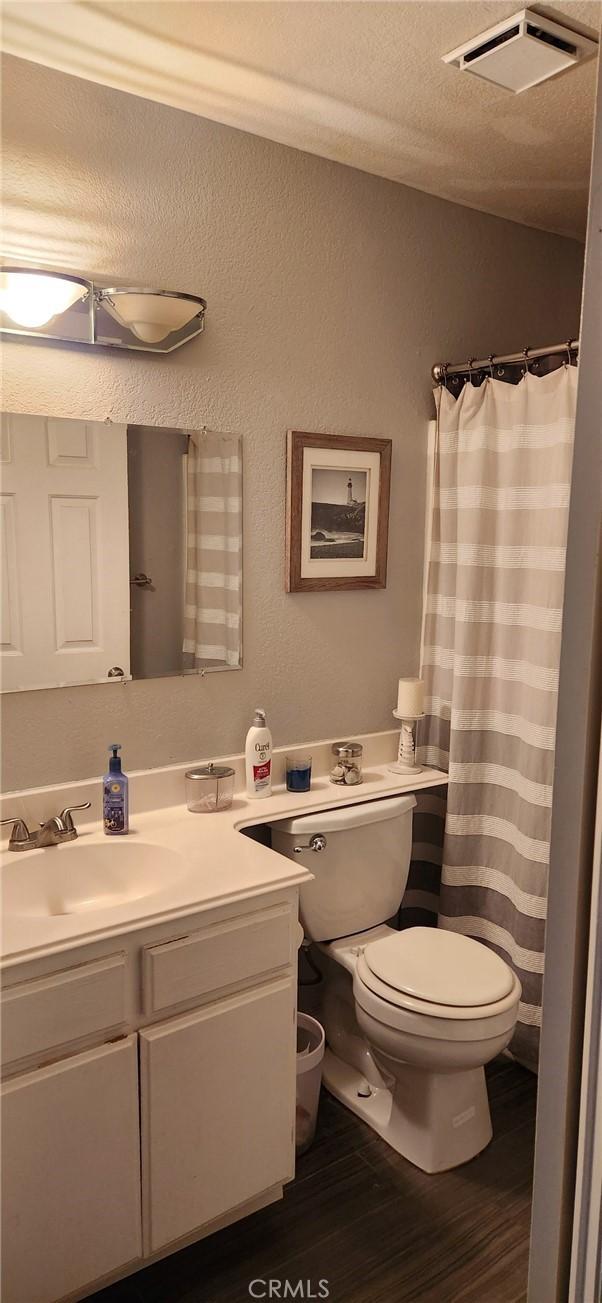 bathroom with vanity, wood-type flooring, and toilet