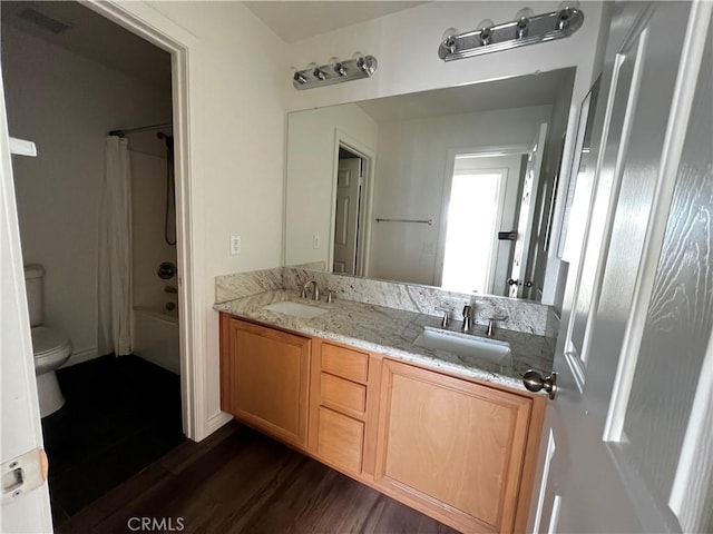 full bathroom with hardwood / wood-style floors, vanity, toilet, and shower / bath combo with shower curtain