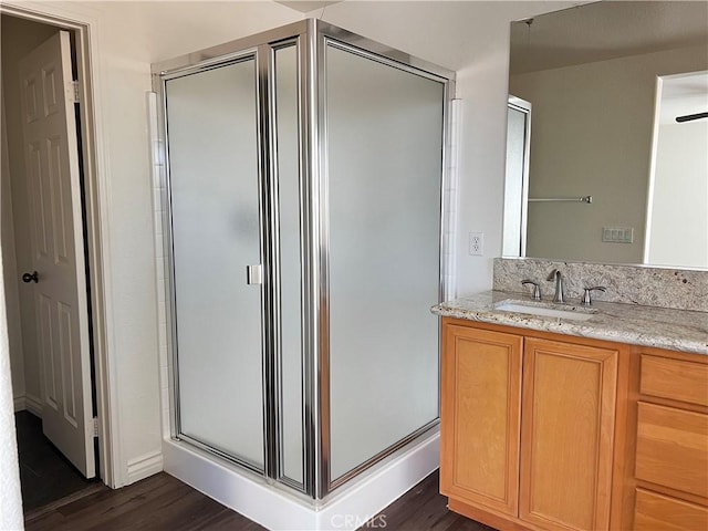 bathroom with hardwood / wood-style floors, vanity, ceiling fan, and an enclosed shower