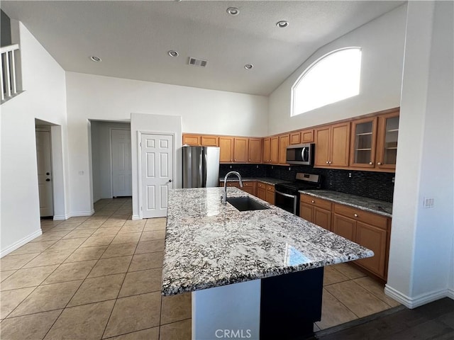 kitchen with sink, an island with sink, and appliances with stainless steel finishes