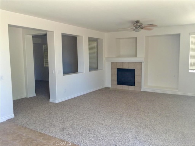 unfurnished living room featuring ceiling fan, a fireplace, and light colored carpet