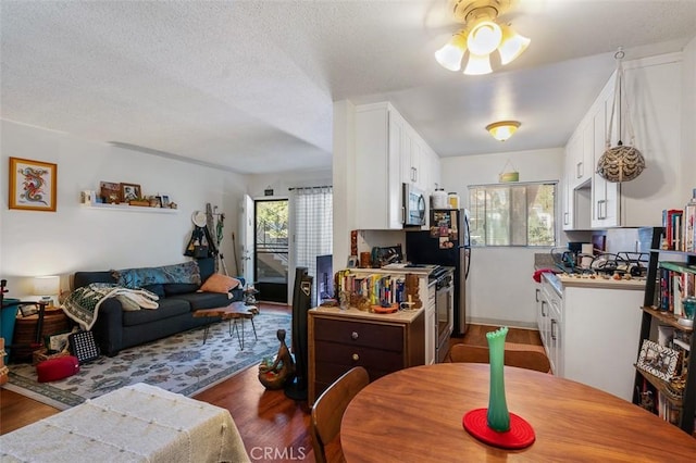 dining area featuring ceiling fan, a textured ceiling, and dark hardwood / wood-style floors