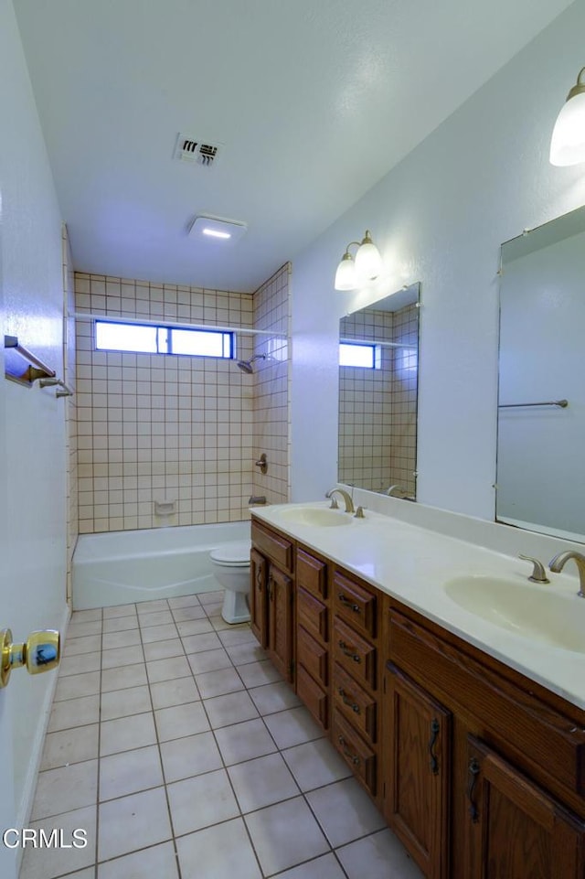 full bathroom with toilet, vanity, tiled shower / bath combo, and tile patterned flooring