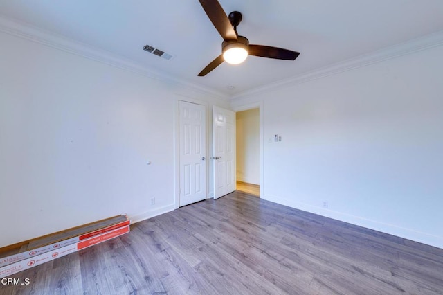 unfurnished room with ceiling fan, ornamental molding, and wood-type flooring