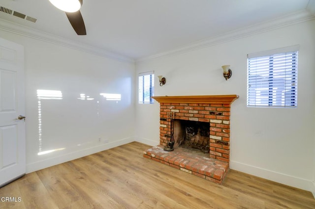 unfurnished living room with ceiling fan, a brick fireplace, crown molding, and light hardwood / wood-style floors