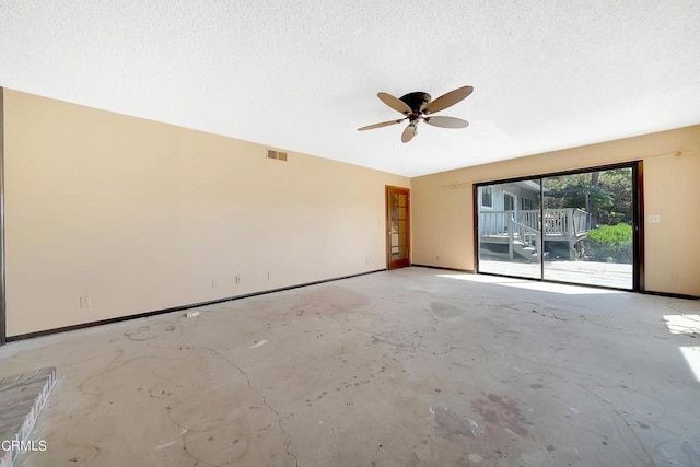 empty room with ceiling fan and a textured ceiling