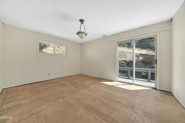 unfurnished room with a textured ceiling