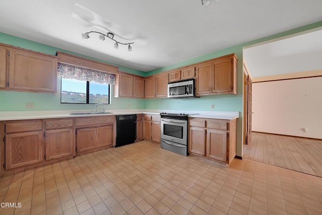 kitchen with sink, light hardwood / wood-style flooring, and appliances with stainless steel finishes