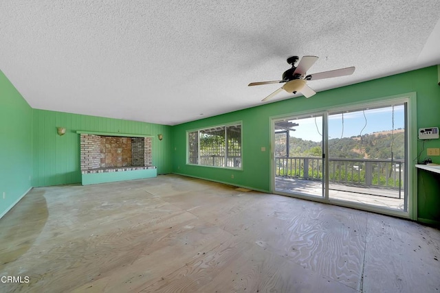 unfurnished living room featuring ceiling fan and a textured ceiling