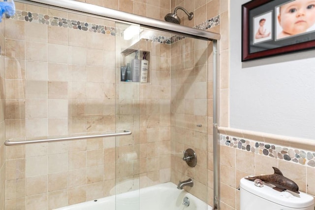 bathroom featuring enclosed tub / shower combo, tile walls, and toilet