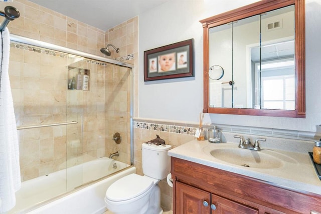 full bathroom featuring shower / bath combo, toilet, tile walls, and vanity