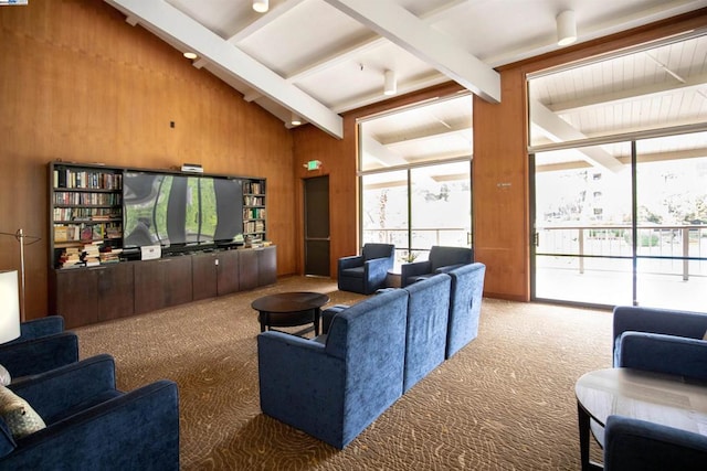 carpeted living room featuring wooden walls and lofted ceiling with beams