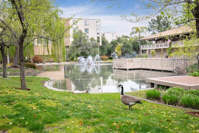 view of community featuring a lawn and a water view