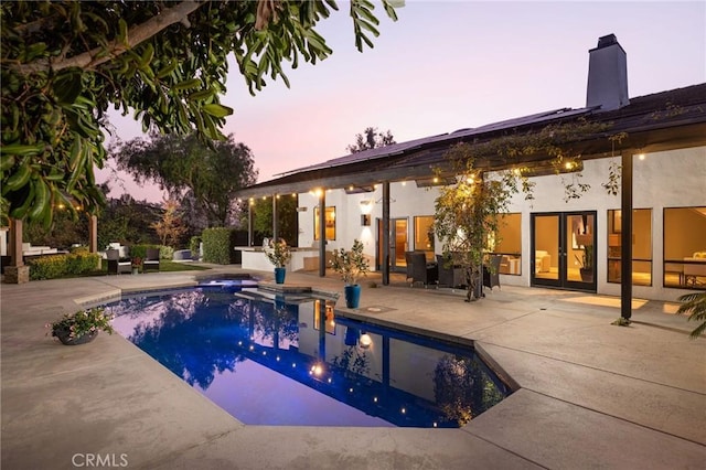 pool at dusk featuring a patio area