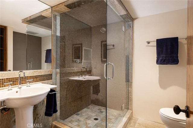 bathroom with decorative backsplash, sink, toilet, and walk in shower