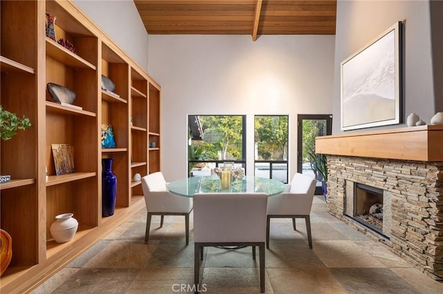 dining area featuring beam ceiling, wood ceiling, a fireplace, and high vaulted ceiling