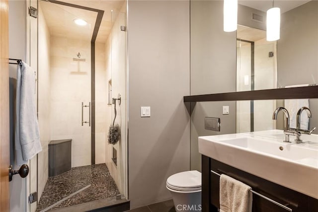 bathroom featuring tile patterned floors, walk in shower, vanity, and toilet