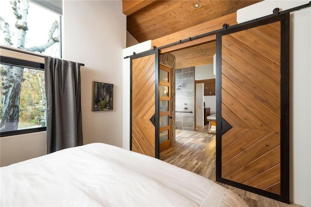 bedroom featuring lofted ceiling, wood ceiling, and a barn door