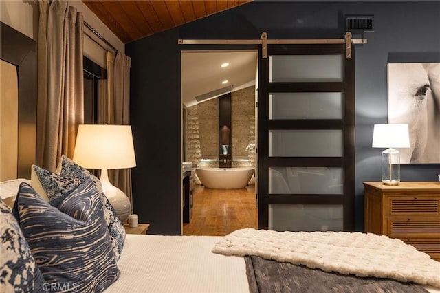 bedroom with a barn door, vaulted ceiling, wood ceiling, and wood-type flooring