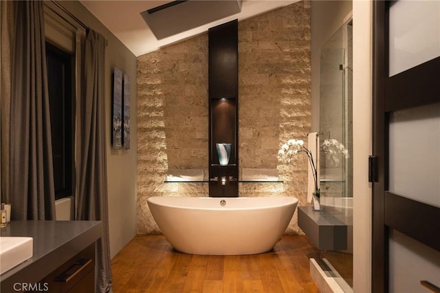 bathroom featuring hardwood / wood-style flooring, vanity, lofted ceiling, and shower with separate bathtub