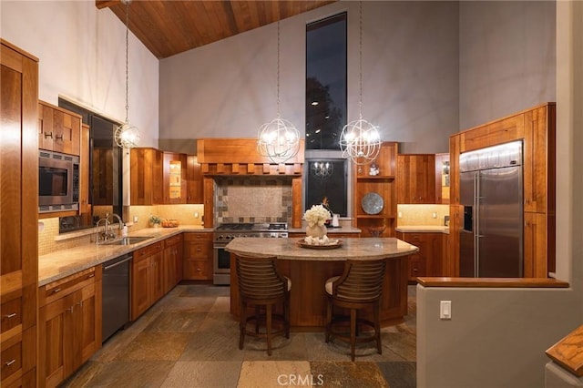 kitchen with built in appliances, sink, a towering ceiling, and a kitchen island