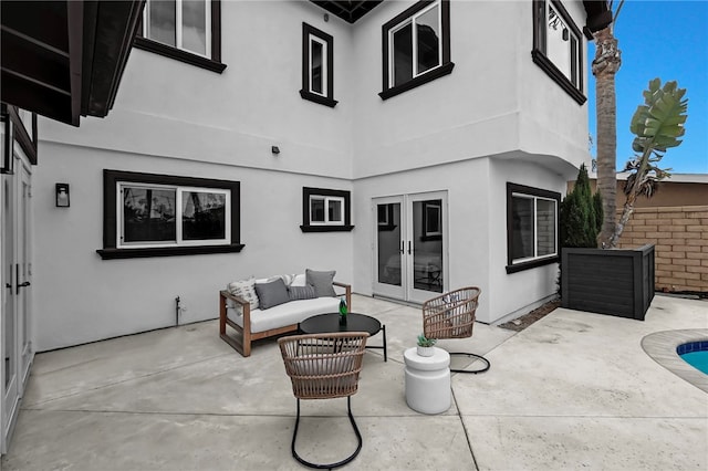 view of patio featuring an outdoor pool, french doors, fence, and an outdoor living space