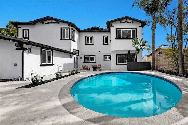 back of property featuring a fenced in pool, fence, a patio, and stucco siding