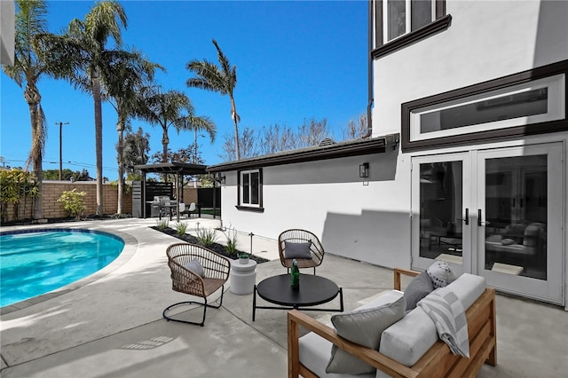 view of pool featuring outdoor dining area, a fenced backyard, french doors, a fenced in pool, and a patio area