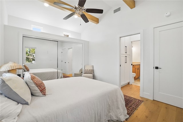 bedroom featuring beam ceiling, visible vents, connected bathroom, ceiling fan, and light wood-type flooring