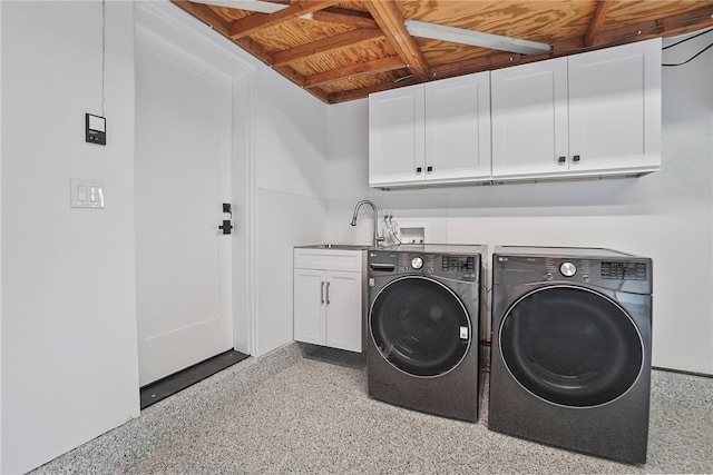 laundry area featuring separate washer and dryer, a sink, and cabinet space