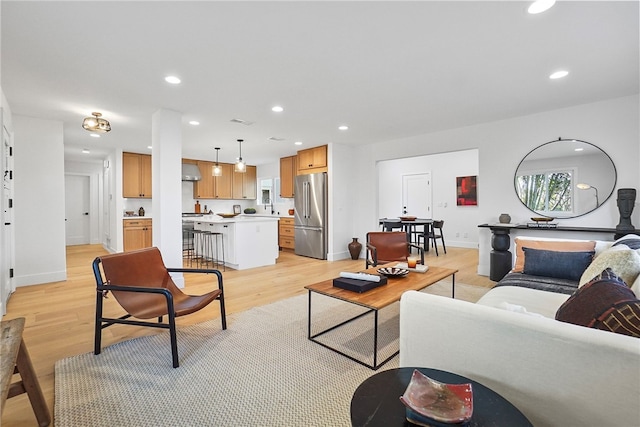 living room with light wood-style flooring, baseboards, and recessed lighting