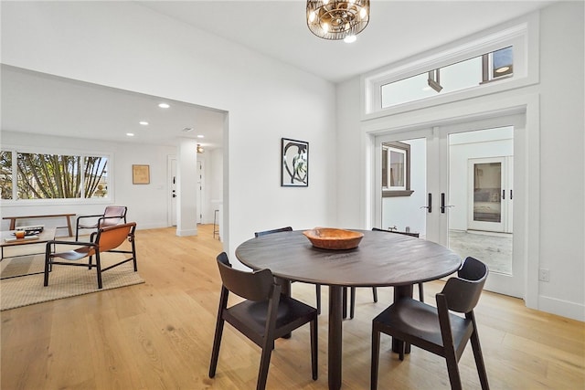 dining space with baseboards, light wood-style flooring, an inviting chandelier, french doors, and recessed lighting