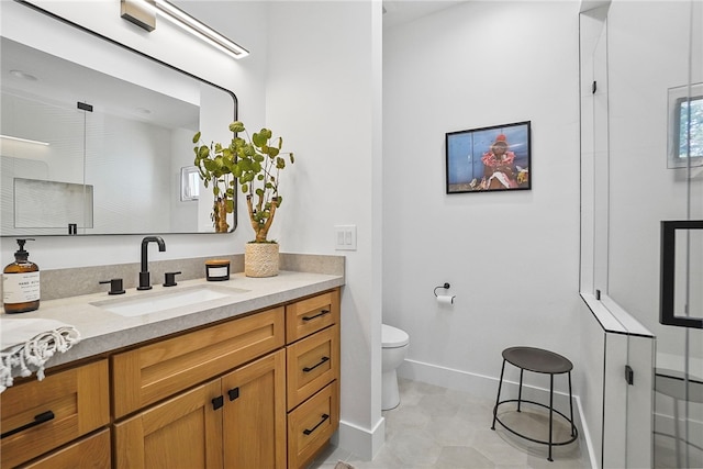 full bath featuring toilet, vanity, a shower with shower door, and baseboards