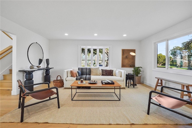 living room featuring recessed lighting, baseboards, stairway, and light wood finished floors