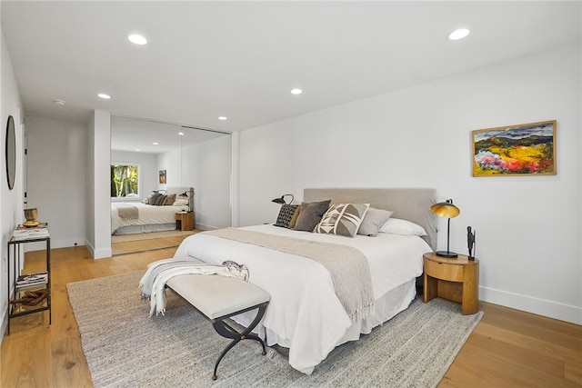 bedroom with baseboards, a closet, light wood-type flooring, and recessed lighting