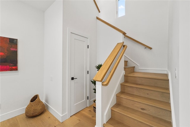 staircase with wood finished floors and baseboards