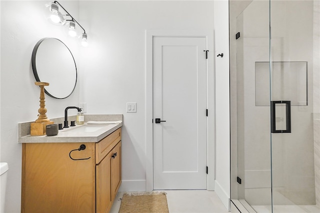 bathroom featuring toilet, a stall shower, baseboards, and vanity