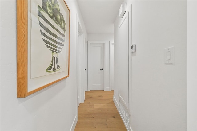 hallway with light wood-style flooring and baseboards