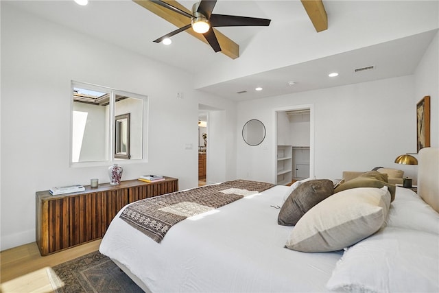 bedroom with ceiling fan, recessed lighting, wood finished floors, visible vents, and beam ceiling