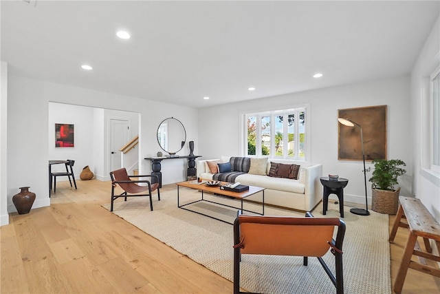 living area with baseboards, light wood finished floors, and recessed lighting