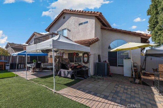 back of property featuring a lawn, an outdoor hangout area, and a patio area