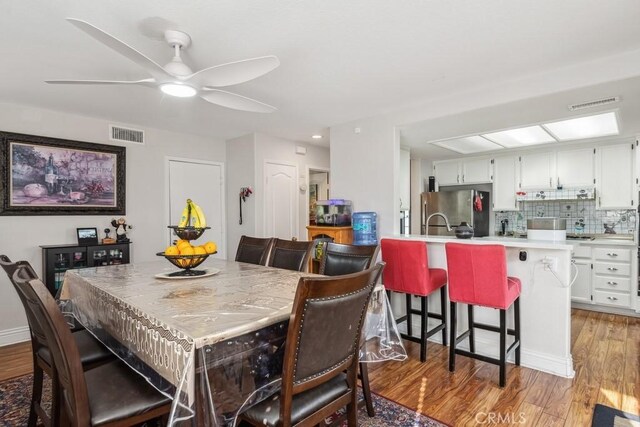 dining area with ceiling fan and light hardwood / wood-style floors